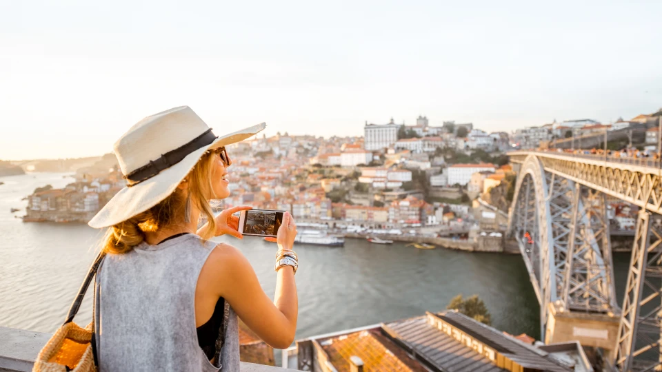 turista a tirar fotos a ponte Dom Luis I na cidade do porto - efacont