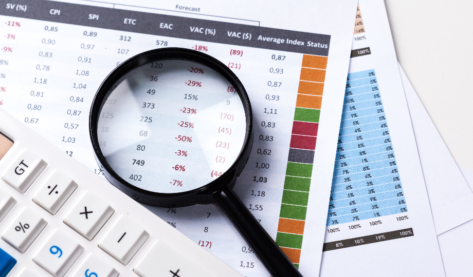 Uma lupa é colocada sobre um documento exibindo dados financeiros, destacando números em preto e vermelho que revelam insights sobre juros simples. Papéis adjacentes mostram um gráfico de barras colorido e mais dados. Uma calculadora branca é parcialmente visível no canto inferior esquerdo, com uma caneta branca por perto. - Efacont