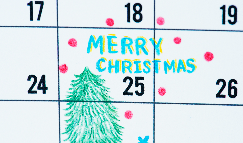 Um close-up de um calendário mostra o dia 25 de dezembro marcado com "Feliz Natal" em letras coloridas desenhadas à mão. Pontos vermelhos e uma árvore verde complementam o cenário festivo, destacando como o que são necessidades cíclicas surge em épocas especiais do ano. - Efacont